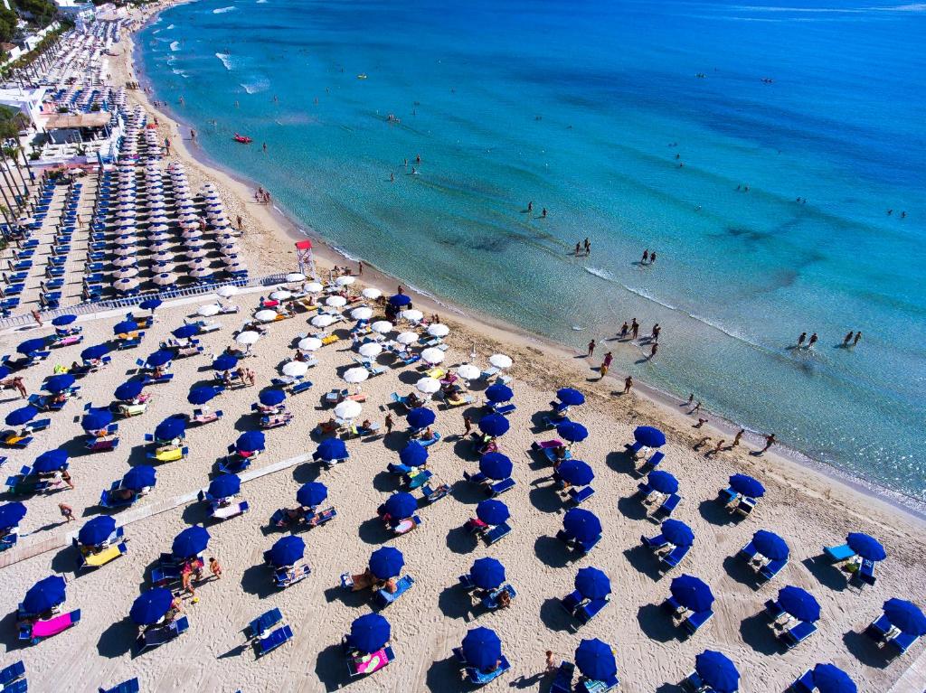 une vue aérienne d'une plage avec des chaises et des parasols dans l'établissement Futura Club Spiagge Bianche, à Fontane Bianche