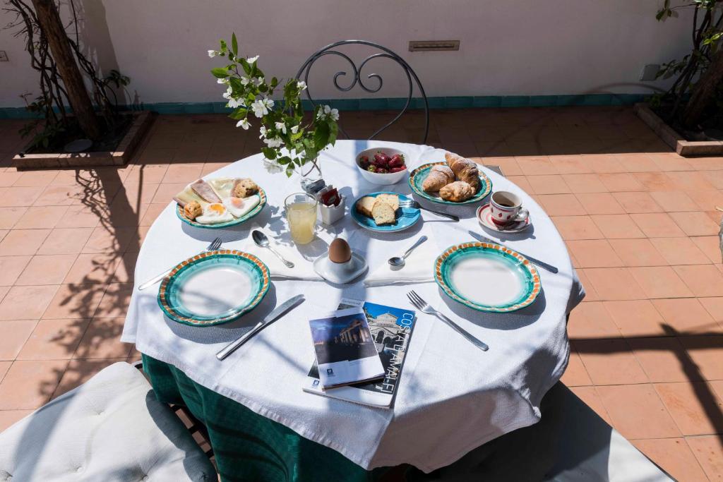 une table avec des assiettes de nourriture dessus dans l'établissement Hotel Relais Villa Annalara, à Amalfi