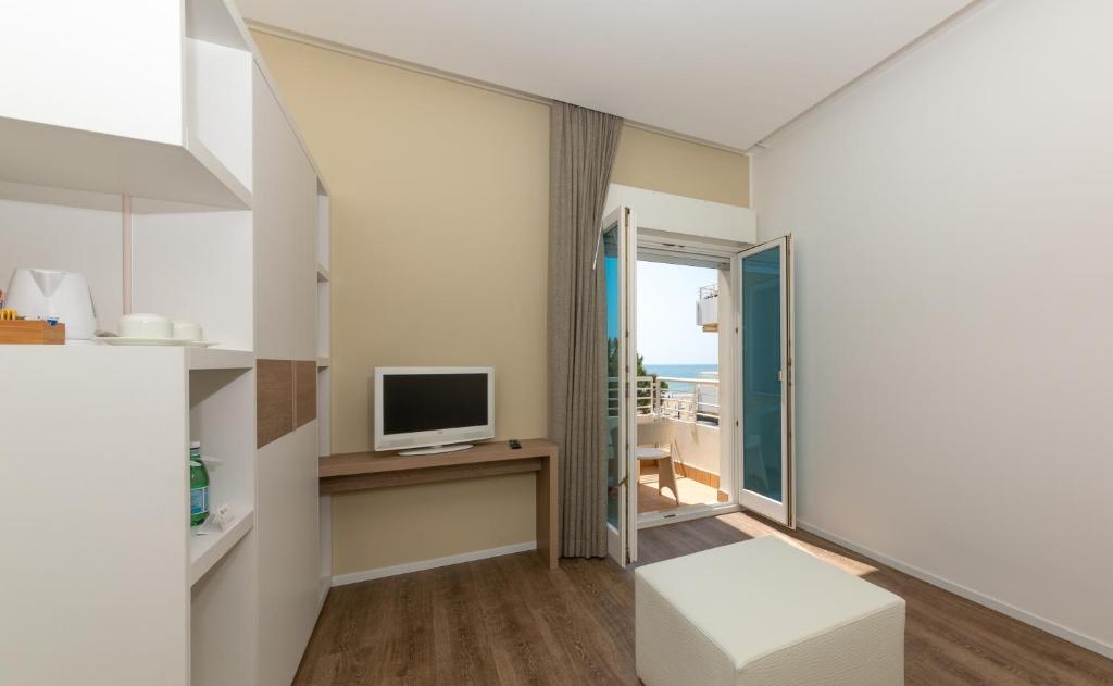 un salon avec une télévision et un canapé dans l'établissement Hotel Aurora, à Lido di Jesolo