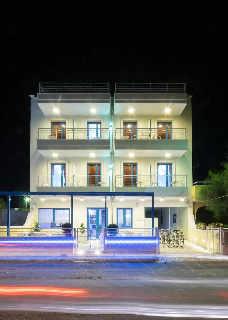 un grand bâtiment blanc la nuit avec une rue dans l'établissement Hotel Perla Dello Ionio, à Torre Lapillo