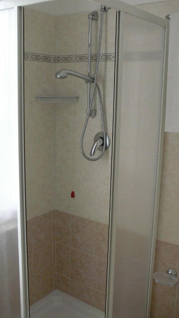 une douche avec une porte vitrée dans une salle de bain dans l'établissement Hotel Mario, à San Benedetto del Tronto