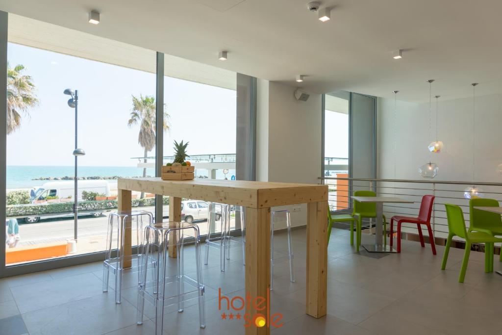 une salle à manger avec une table et des chaises et l'océan dans l'établissement Hotel Sole, à Montesilvano