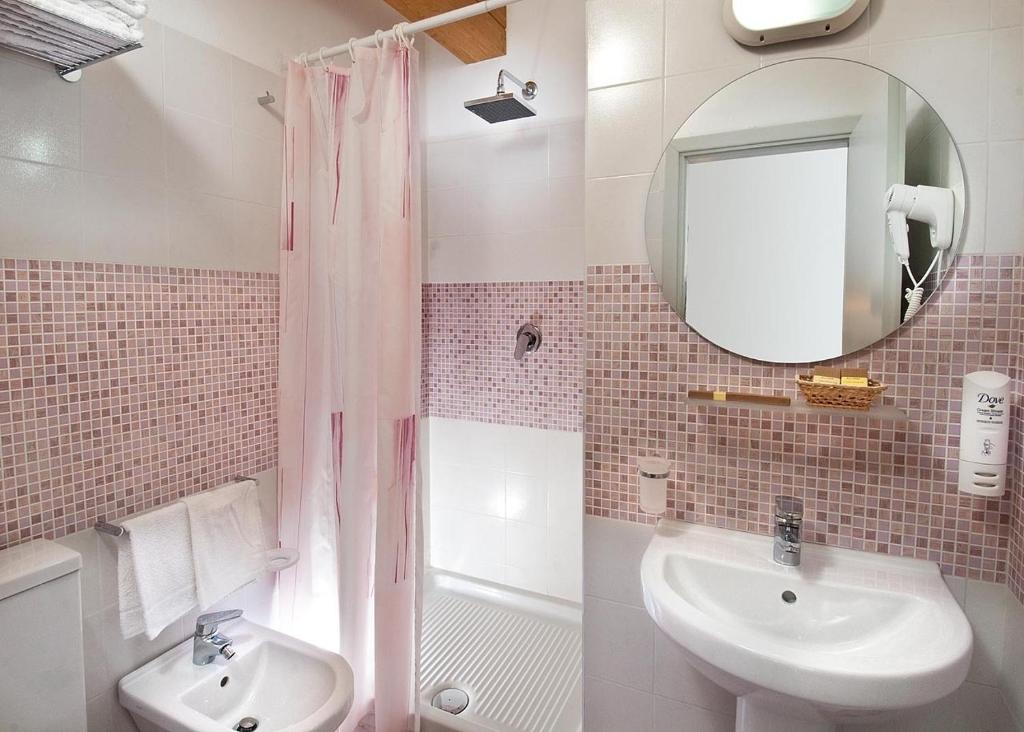 une salle de bain avec un lavabo et une douche avec un miroir dans l'établissement Hotel Saint Tropez SPA & Restaurant, à Lido di Savio