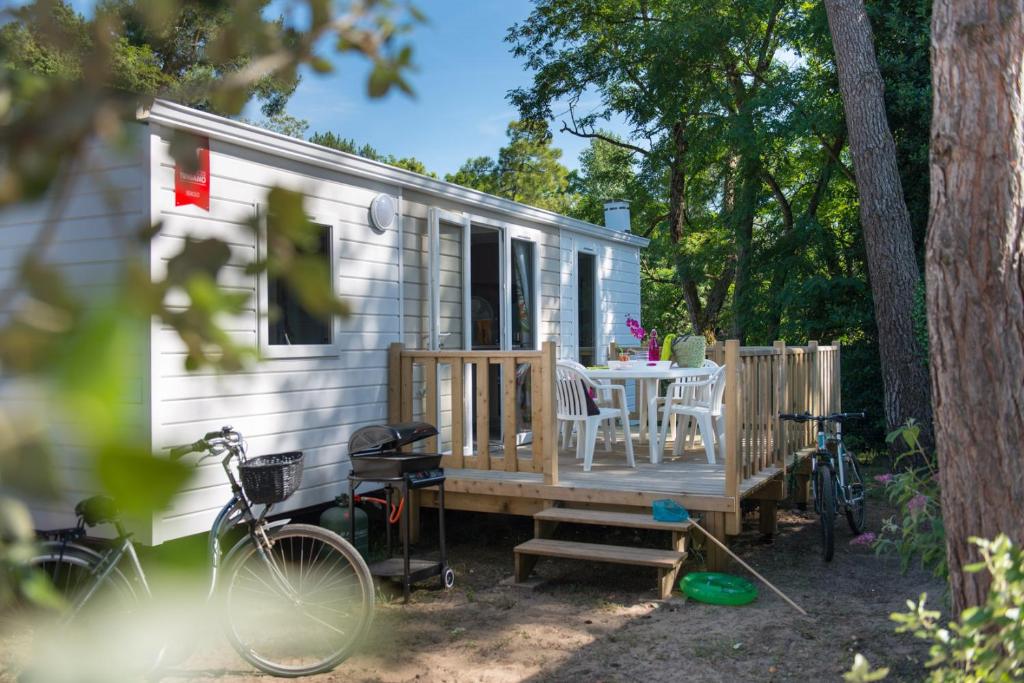 une petite maison avec une table et des chaises sur la terrasse couverte dans l'établissement Camping Officiel Siblu le Montourey, à Fréjus