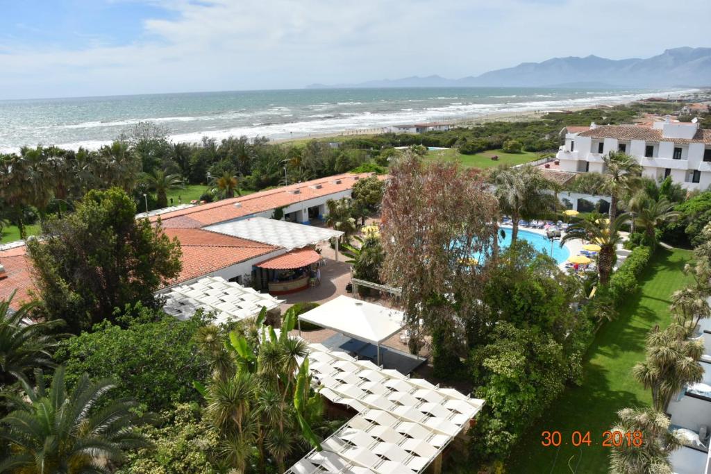 une vue aérienne d'un complexe hôtelier avec piscine et l'océan dans l'établissement Marina Club Hotel, à Baia Domizia