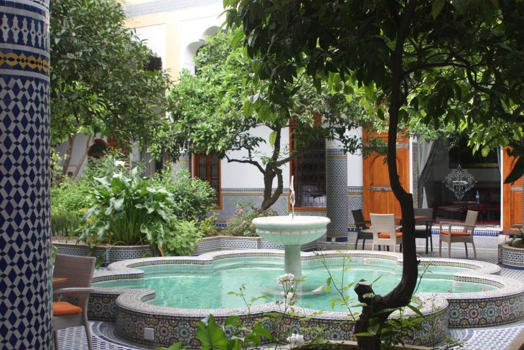 une fontaine au milieu d'une cour arborée dans l'établissement Palais Amani, à Fès