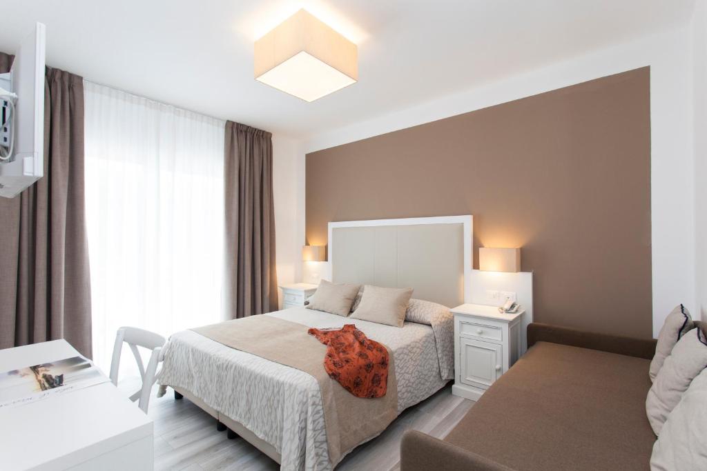 une chambre avec un lit et une chaise dedans dans l'établissement Hotel Greif, à Lido di Jesolo