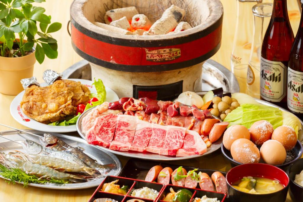 une table recouverte de assiettes de nourriture à côté d'un tonneau de vin dans l'établissement Yufuin Inakamura Inakaso, à Yufu 22 autres photos