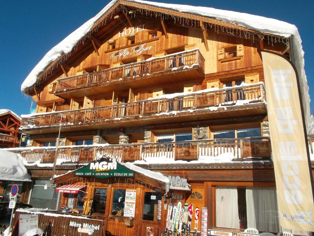 un grand bâtiment en bois avec un balcon enneigé dans l'établissement Alp'azur, à L'Alpe-d'Huez
