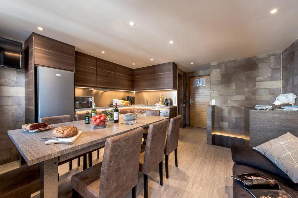une cuisine avec une grande table et des chaises en bois dans l'établissement Tignes 304, à Tignes 17 autres photos
