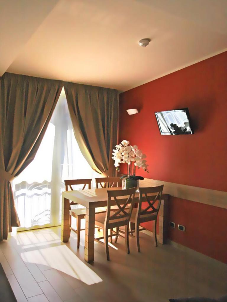 - une salle à manger avec une table et des fleurs dans l'établissement Relais Concorde, à Grottammare