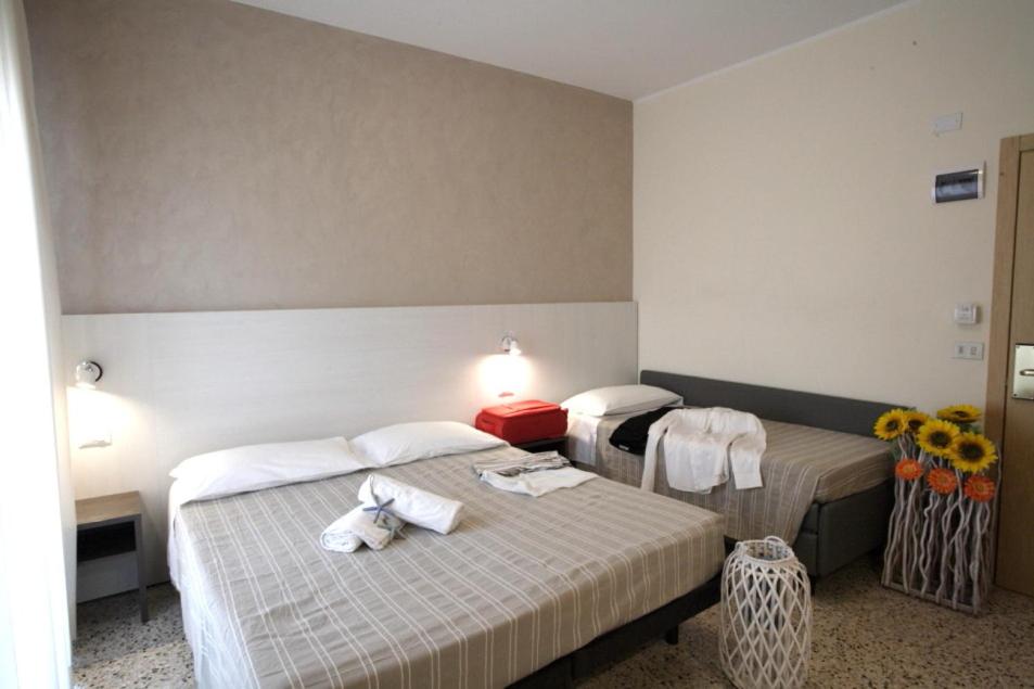 deux lits dans une chambre d'hôtel avec des serviettes dessus dans l'établissement Hotel Tosi, à Riccione