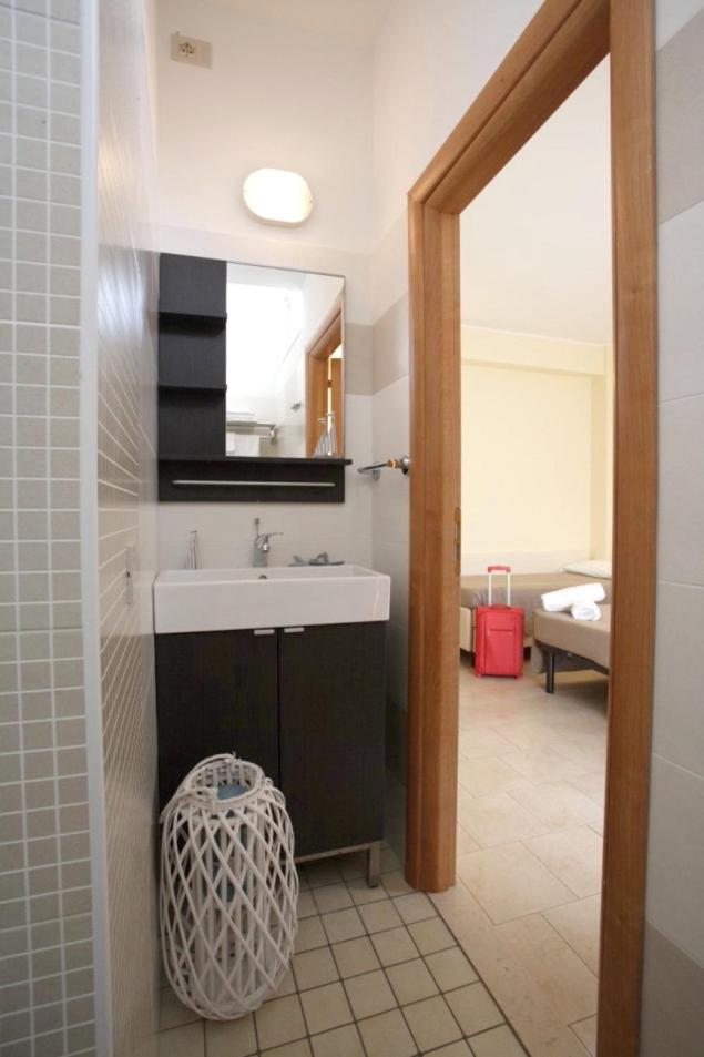 une salle de bain avec un lavabo et un miroir dans l'établissement Hotel Tosi, à Riccione