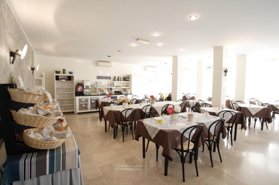 un restaurant avec des tables et des chaises dans une salle dans l'établissement Hotel Tosi, à Riccione