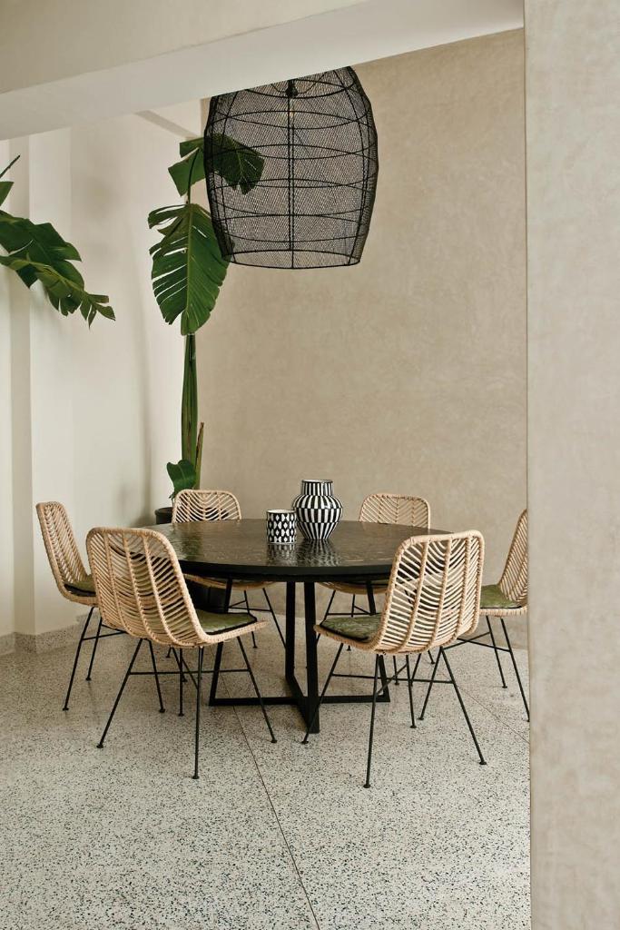 une salle à manger avec une table et des chaises noires dans l'établissement Numa Marrakech, à Marrakech