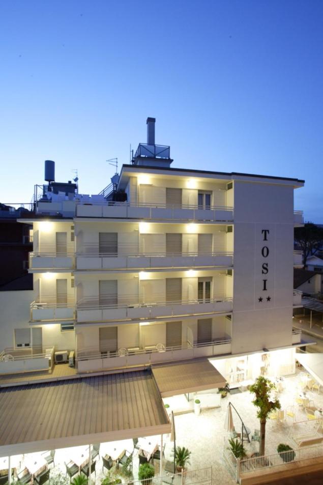 un grand bâtiment blanc avec un hôtel dans l'établissement Hotel Tosi, à Riccione