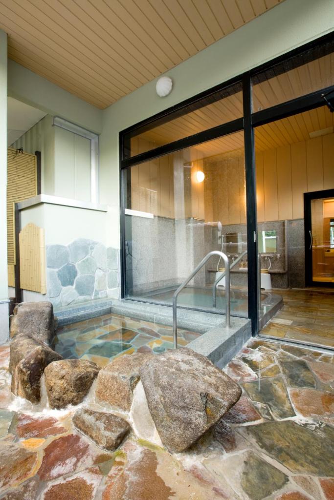 - un bain à remous avec des rochers au milieu d'un bâtiment dans l'établissement Yura No Yado Seifuen, à Achi