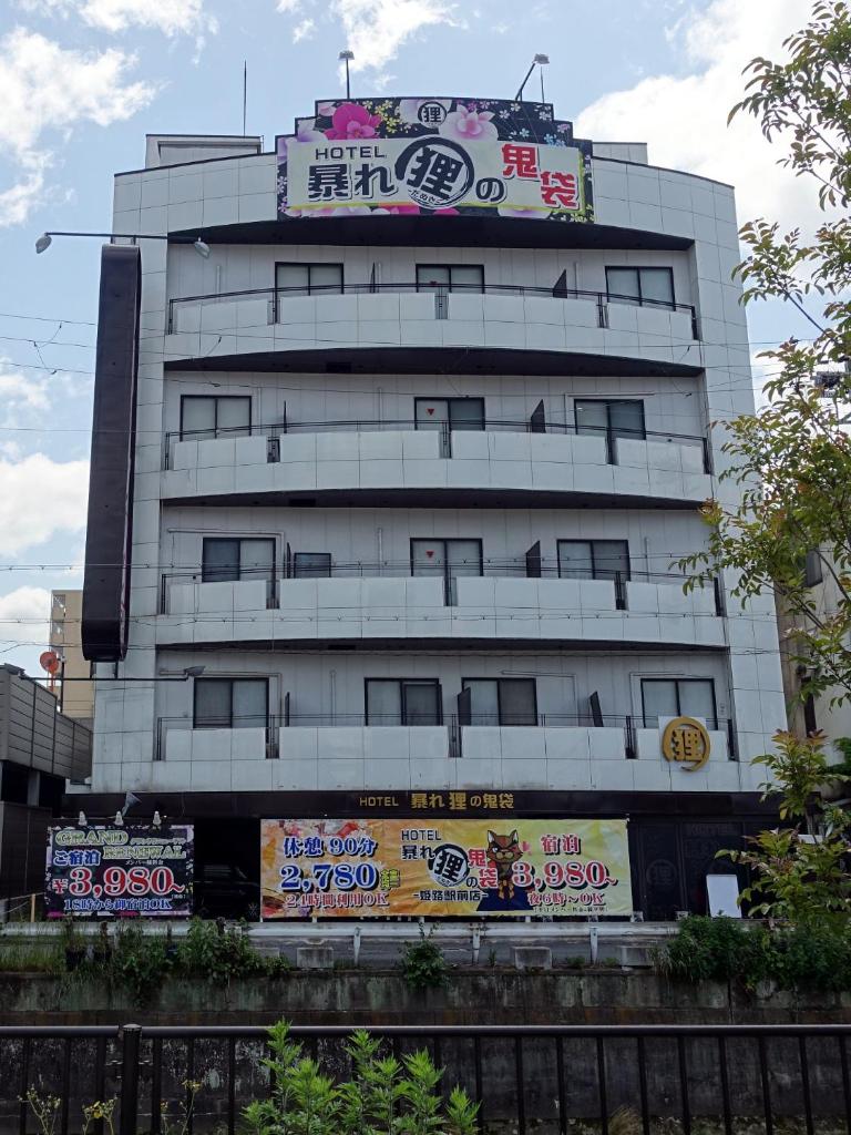 un bâtiment avec des graffitis sur le côté dans l'établissement ホテル暴れ狸の鬼袋姫路駅前店 男塾ホテルグループ, à Himeji