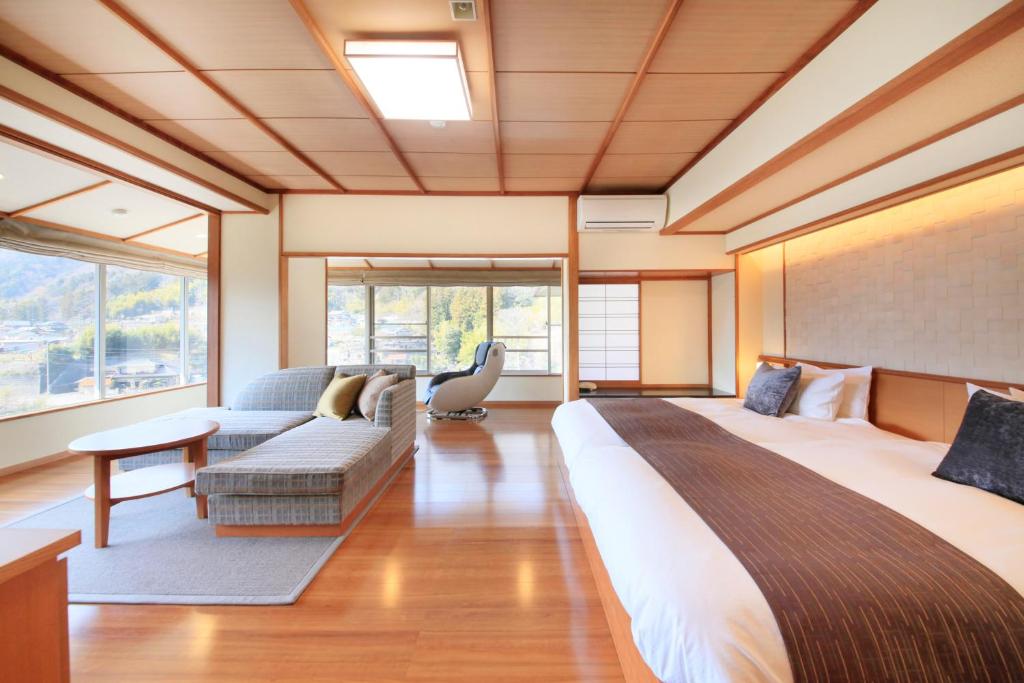 une chambre avec un grand lit et un canapé dans l'établissement Shimobe Hotel, à Minobu
