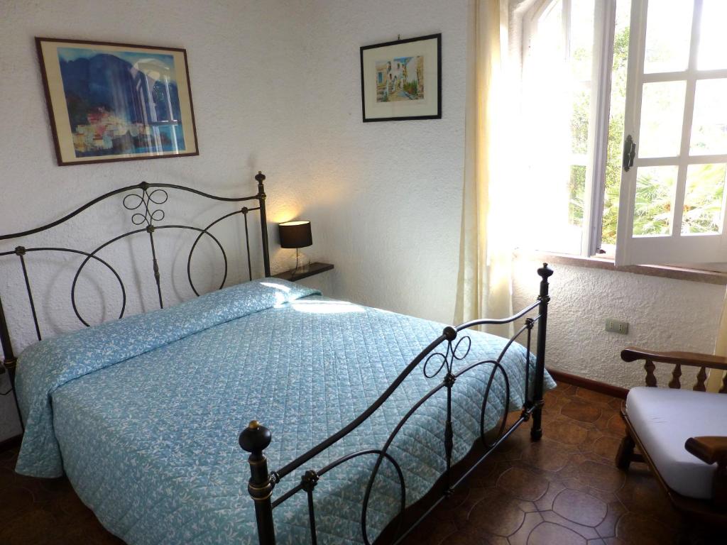 une chambre avec un lit avec une couette bleue dans l'établissement Villa Anna Maria, à Santa Margherita di Pula