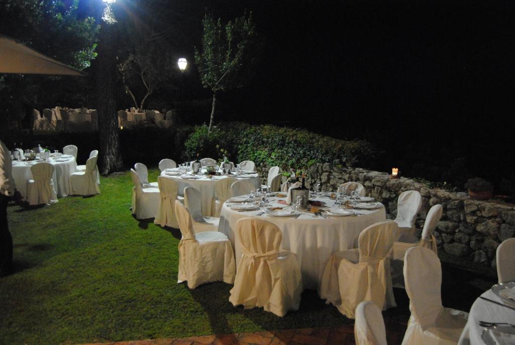 un groupe de tables et de chaises avec un tissu de table blanc dans l'établissement Il Casale, à Formia 32 autres photos