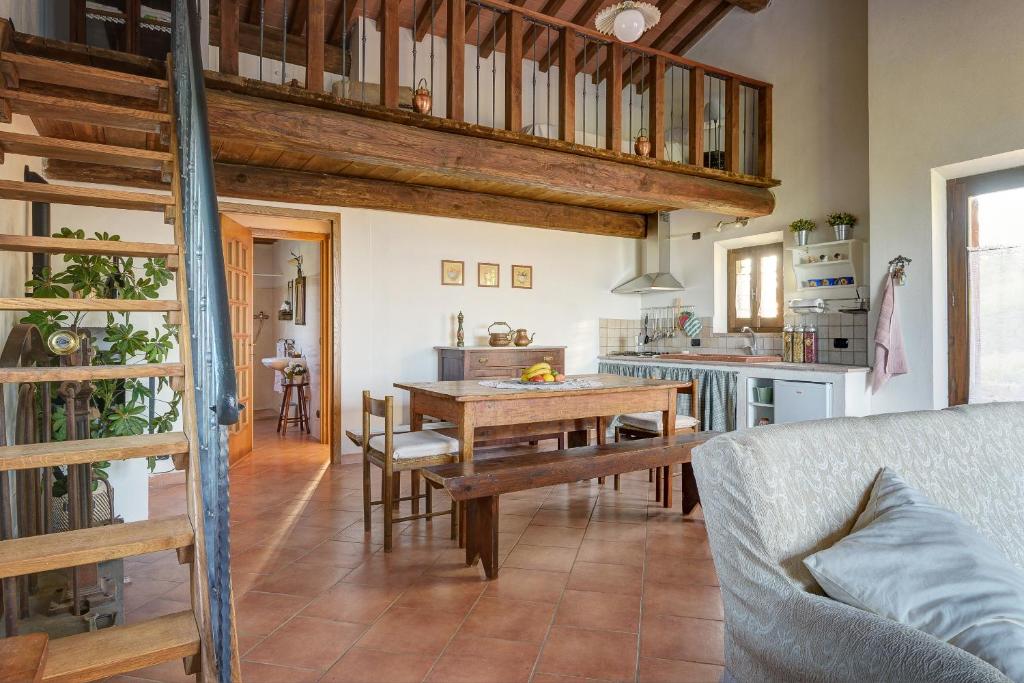 Il dispose d'une cuisine et d'un salon avec une table en bois et un canapé. dans l'établissement SacroFanum Villa, à Sinalunga