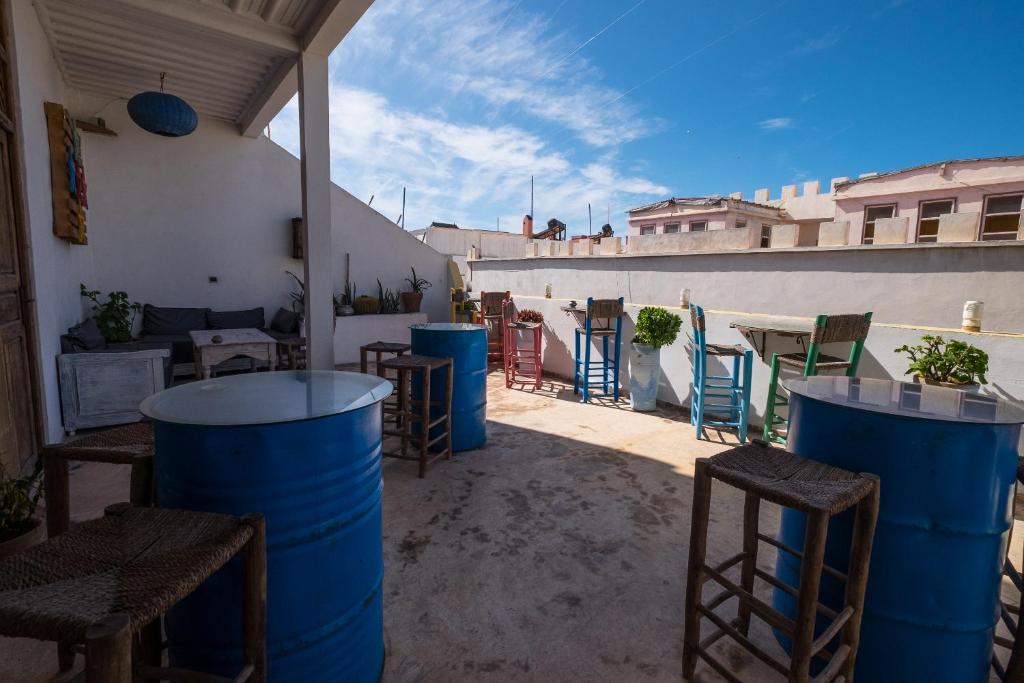 un patio avec des chaises et des tables sur un bâtiment dans l'établissement Riad Inna & Watersports Center, à Essaouira