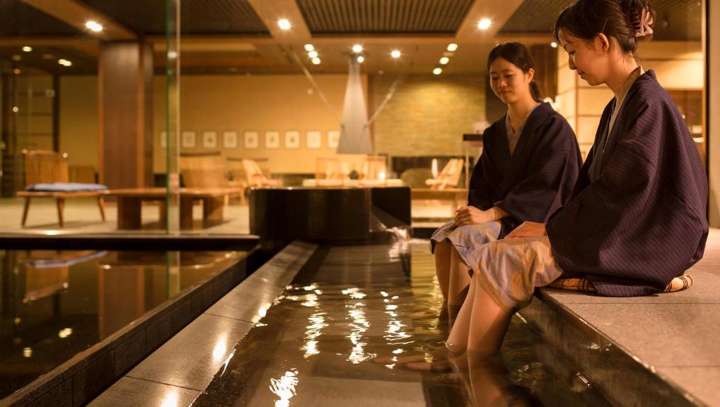 deux femmes assises au bord d'une piscine dans l'établissement Laforet Ito Onsen Yunoniwa, à Itō 37 autres photos