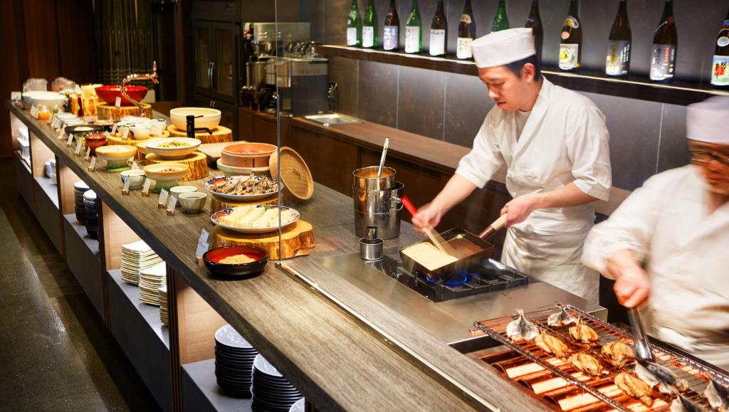 - deux chefs préparant des plats dans la cuisine du restaurant dans l'établissement Laforet Ito Onsen Yunoniwa, à Itō