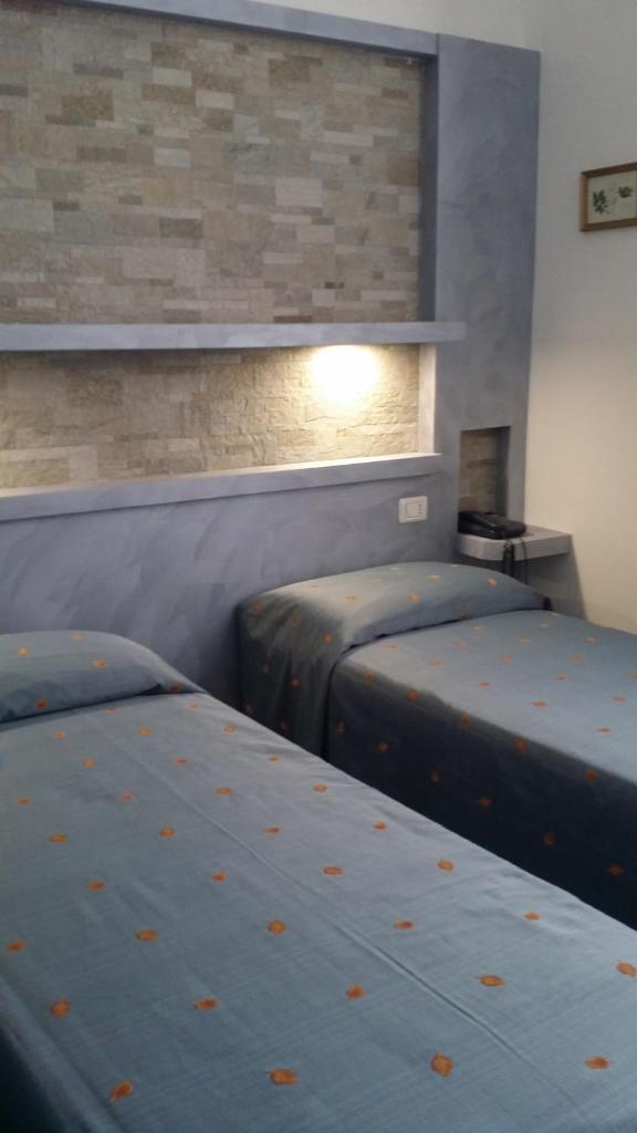 une chambre avec deux lits et un mur de briques dans l'établissement Hotel San Giorgio, à Alassio 34 autres photos