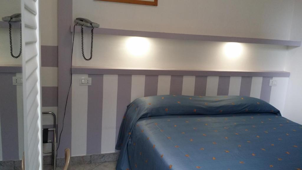 une chambre avec un lit avec une tête de lit rayée dans l'établissement Hotel San Giorgio, à Alassio