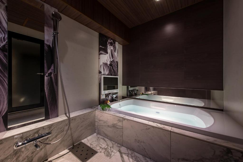 une grande salle de bain avec baignoire et douche dans l'établissement Hotel Zen Ichinomiya (Adult Only), à Ichinomiya