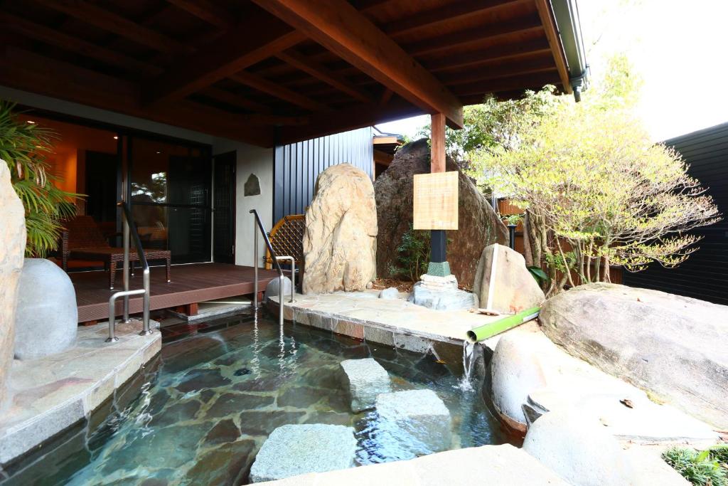 - une piscine avec une cascade dans l'arrière-cour dans l'établissement Uedaya, à Yamaga