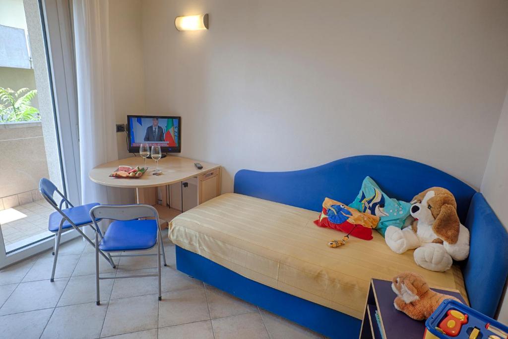 Cette petite chambre comprend un lit bleu et un bureau. dans l'établissement San Giorgio Savoia, à Bellaria-Igea Marina