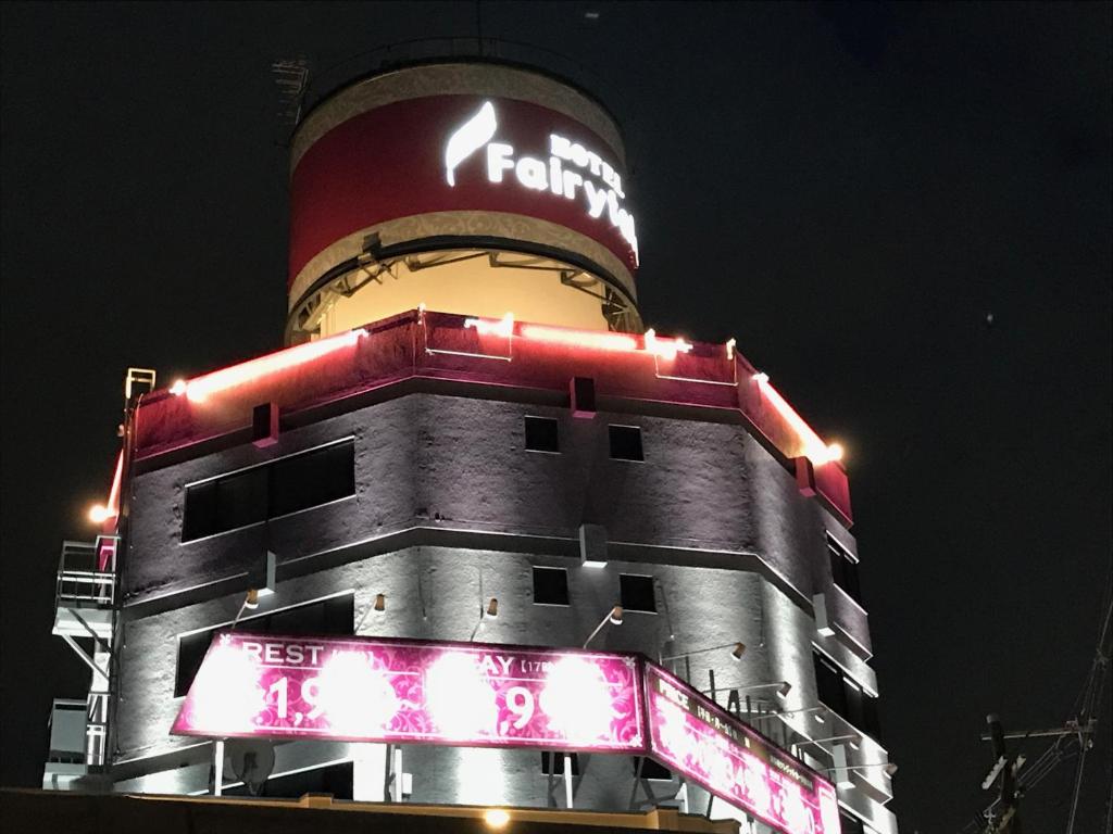 un grand bâtiment avec une enseigne Fendi dessus la nuit dans l'établissement Hotel Fairy Tale (Adult Only), à Toyonaka 4 autres photos