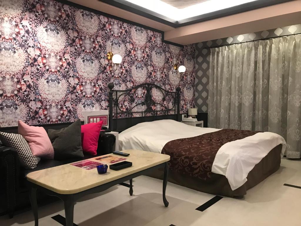 une chambre avec un lit, une table et un canapé dans l'établissement Hotel Fairy Tale (Adult Only), à Toyonaka
