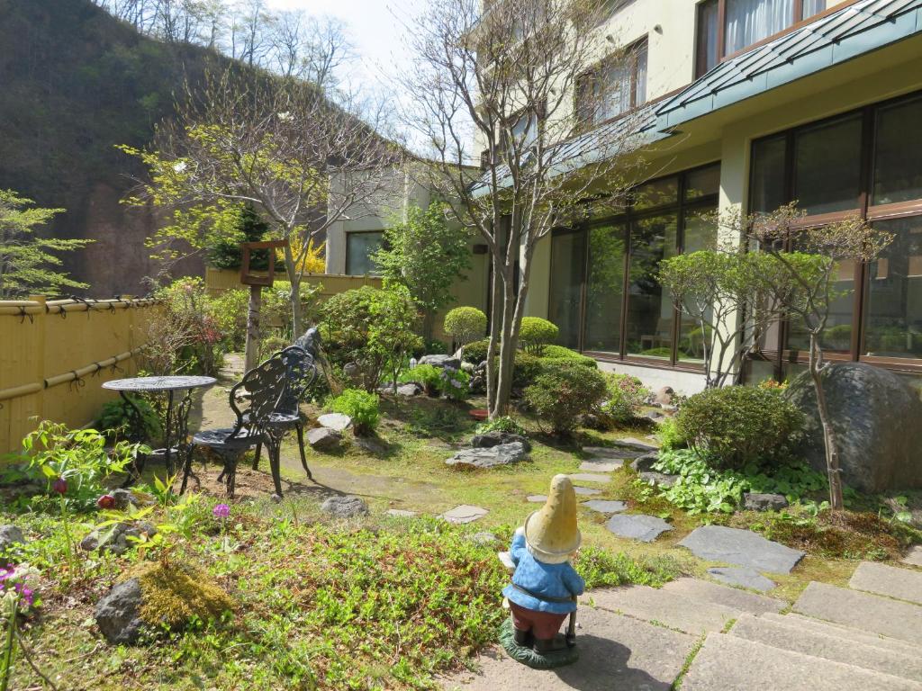 un jardin avec un poulet jouet dans une cour dans l'établissement Kashoutei Hanaya, à Noboribetsu