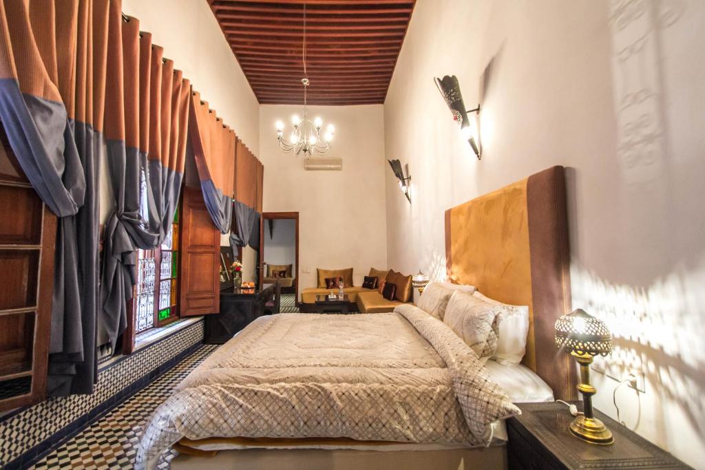 une chambre avec un grand lit dans une pièce dans l'établissement Riad Fez Yamanda, à Fès