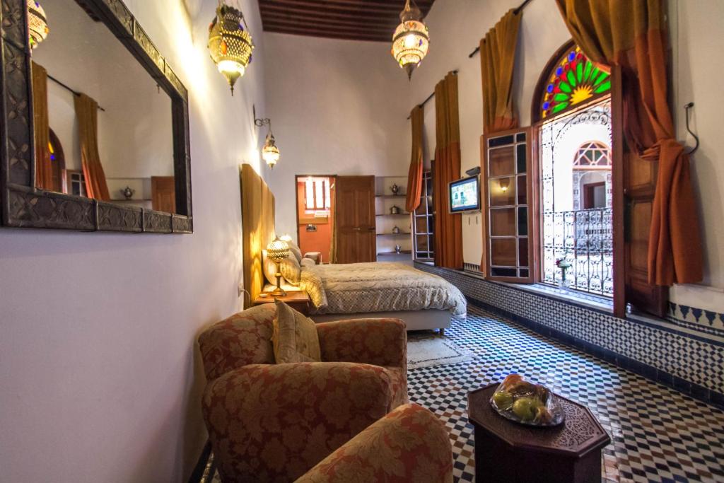 une chambre avec un lit, une chaise et une table dans l'établissement Riad Fez Yamanda, à Fès