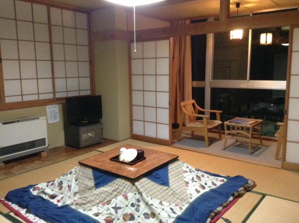 - un salon avec une table sur un tapis dans l'établissement Kadowakikan, à Nozawa Onsen