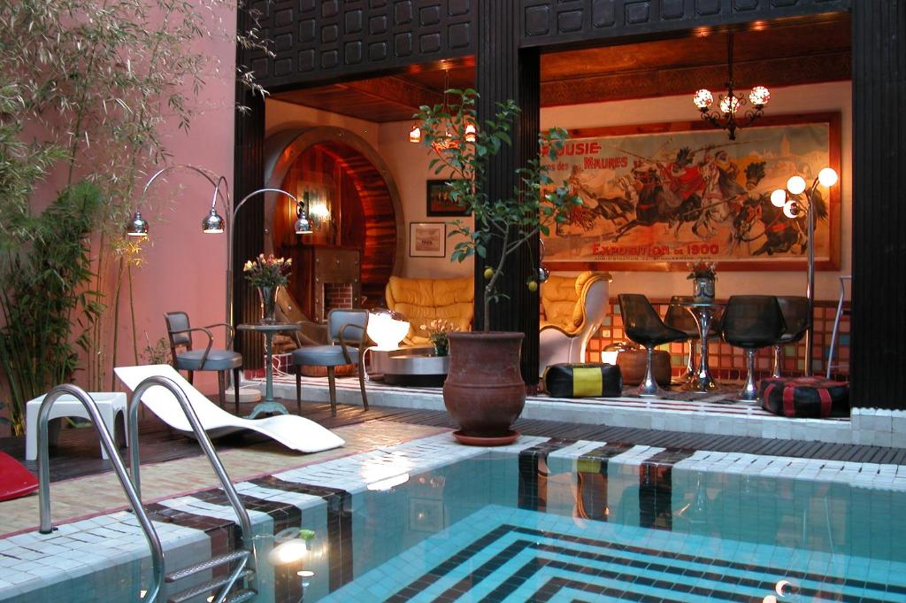 une grande piscine avec des chaises et une table dans l'établissement Riad Malika, à Marrakech