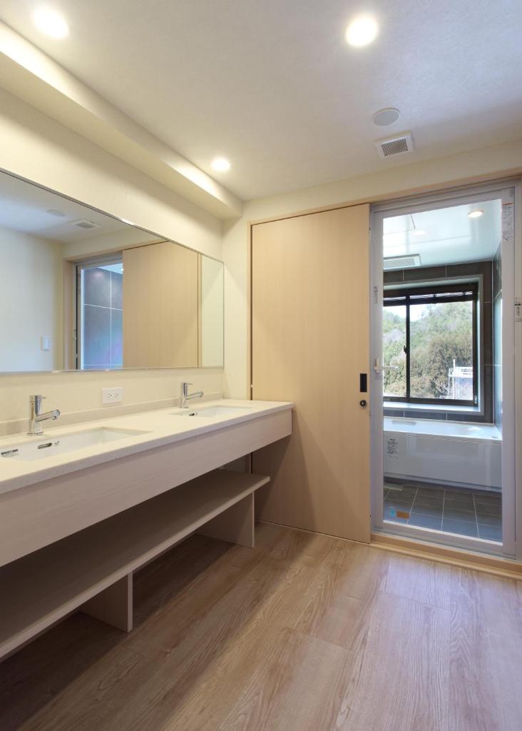 une salle de bain avec deux lavabos et un grand miroir dans l'établissement Ryokan Nenrinbo, à Kyoto