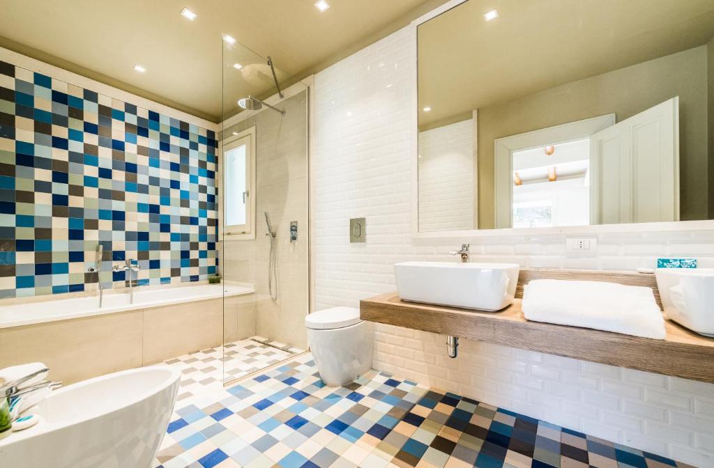 une salle de bain avec un lavabo, des toilettes et une baignoire dans l'établissement Forte Village Resort - Il Borgo, à Santa Margherita di Pula