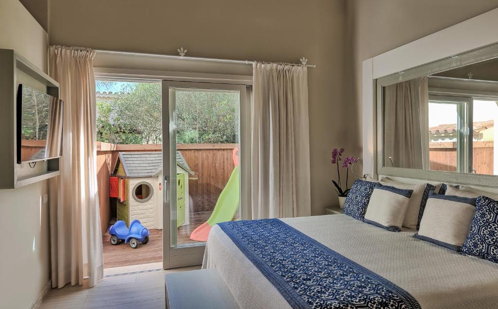 une chambre avec un lit et une porte coulissante en verre dans l'établissement Forte Village Resort - Le Palme, à Santa Margherita di Pula 17 autres photos