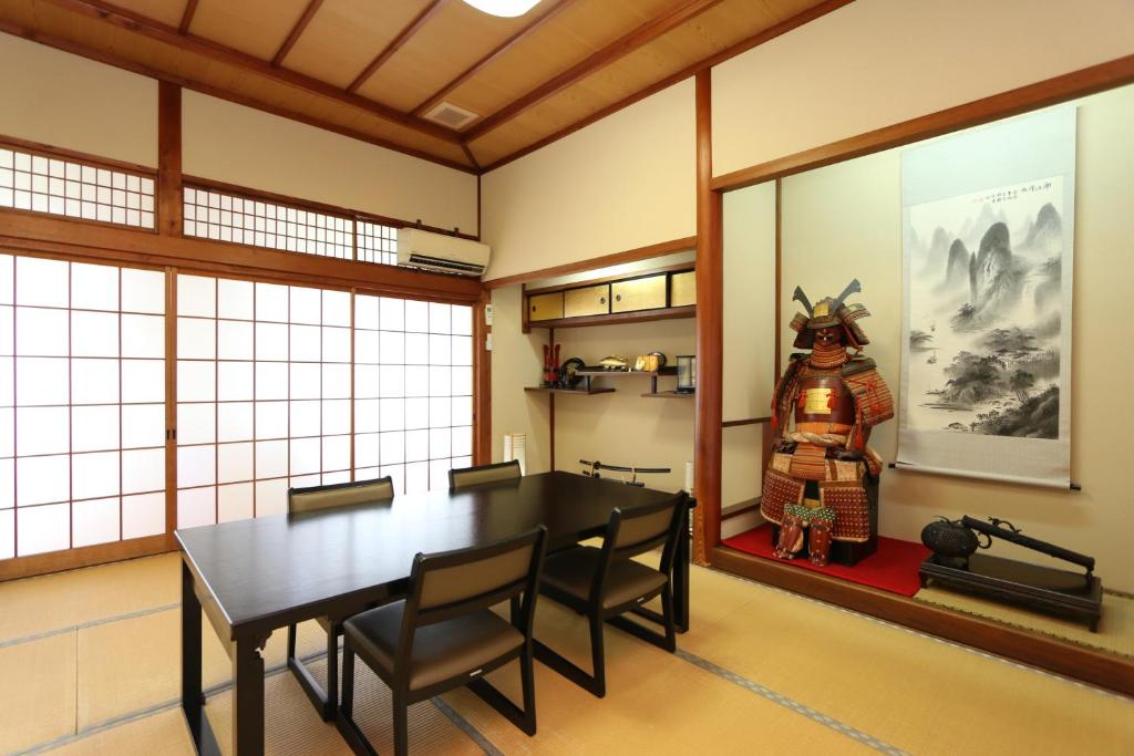 une salle à manger avec une table et une statue de samouraï dans l'établissement Ebisusou, à Takashima