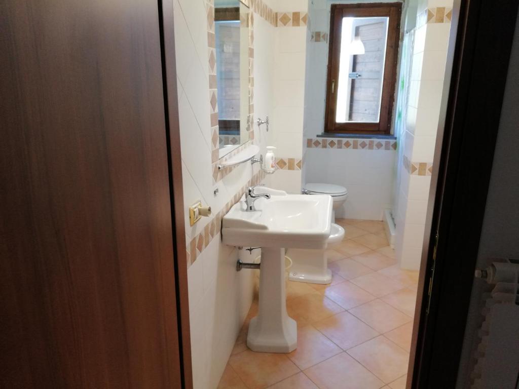 une salle de bain avec un lavabo et des toilettes dans l'établissement Collina delle Rose, à Bagnoregio