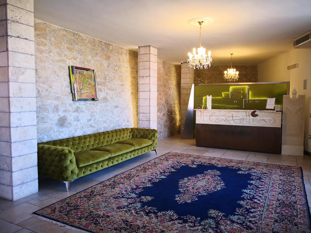 - un salon avec un canapé vert et un tapis dans l'établissement Hotel Boutique Il Castellino Relais, à Vieste