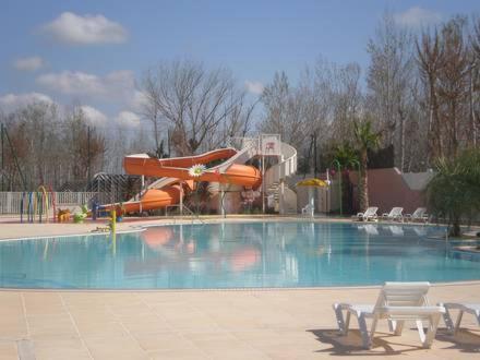 une piscine avec un parc aquatique avec un toboggan dans l'établissement les sables du midi, à Valras-Plage
