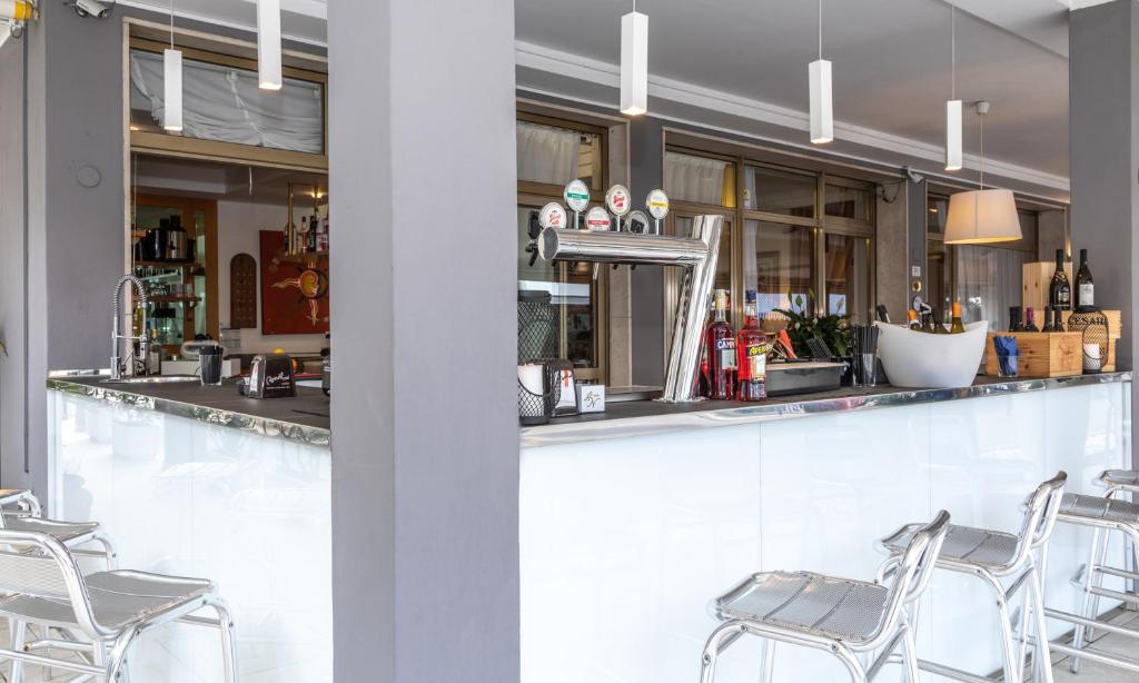 - un bar avec des chaises et un comptoir dans l'établissement Hotel Nazionale, à Lido di Jesolo