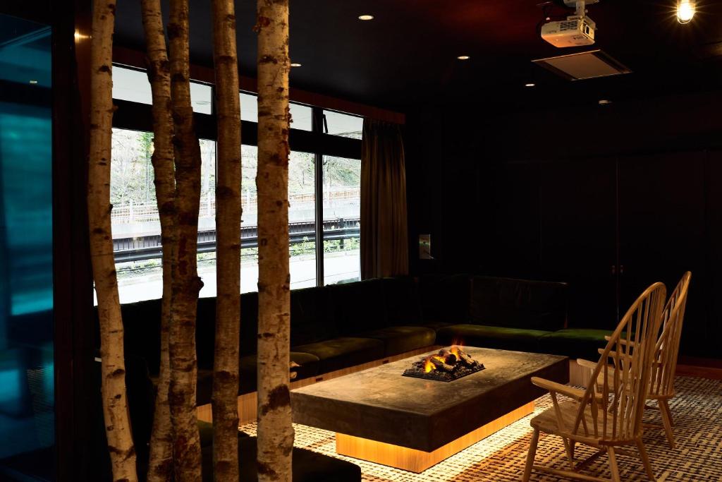 un salon avec un canapé, une table et des chaises dans l'établissement 層雲峡温泉 ホテル雲井, à Kamikawa